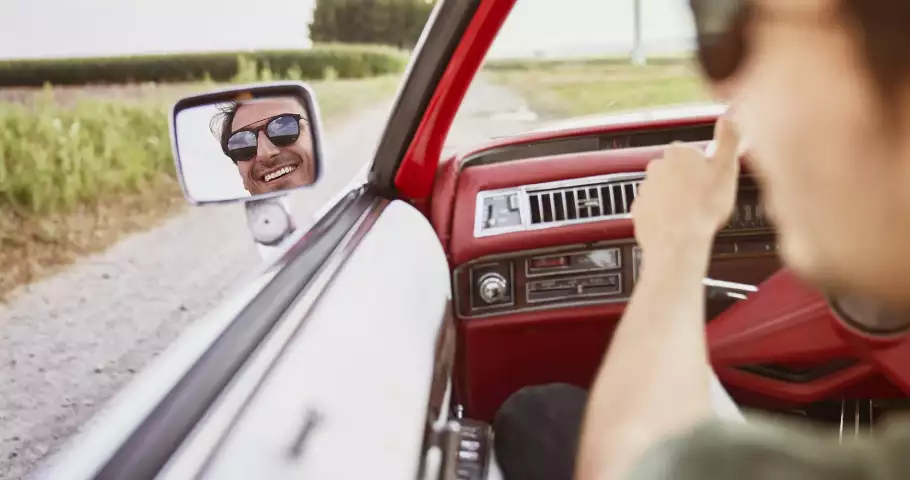 Hombre conduciendo feliz en Europa con su permiso de conducir internacional
