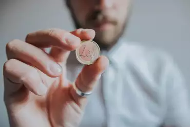 Man holding a euro in his hand
