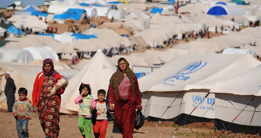 Refugiados caminhando por um acampamento das Nações Unidas