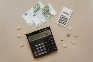 Billetes de 100 euros, monedas y calculadora para hacer la declaración de la renta