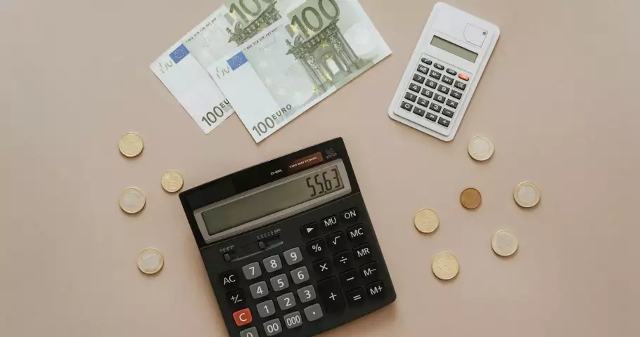 Billetes de 100 euros, monedas y calculadora para hacer la declaración de la renta
