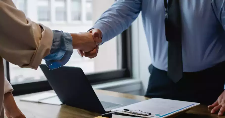 Empleador y empleado se dan la mano después de firmar contrato para un arraigo sociolaboral
